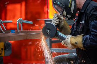 Operator using a cutting wheel on steel