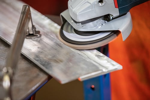 Weld grinding with a flap disc on an uneven aluminum surface