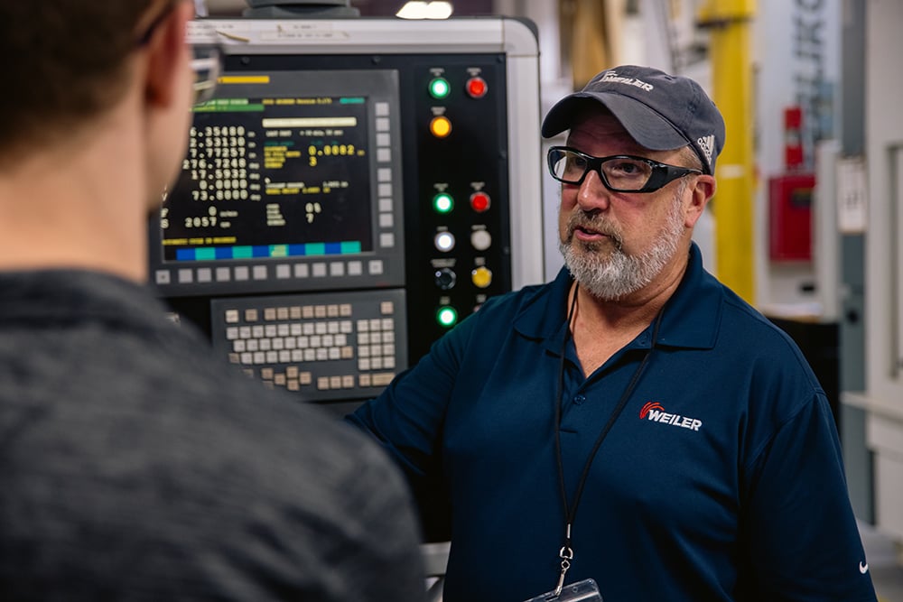 Weiler application expert consulting a gear grinding cell operator.  