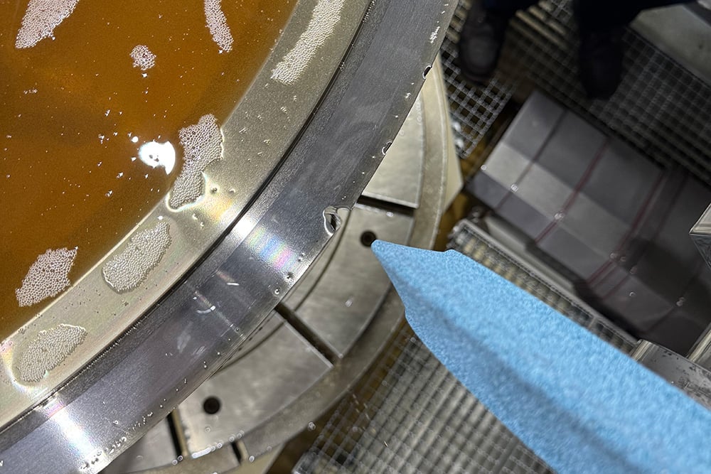 Overhead view of gear grinding wheel approaching and application.