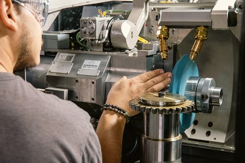 An operator inspecting the profile on a grinding wheel for wear.