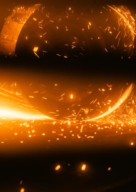 Metal conditioning wheel grinding a steel slab.